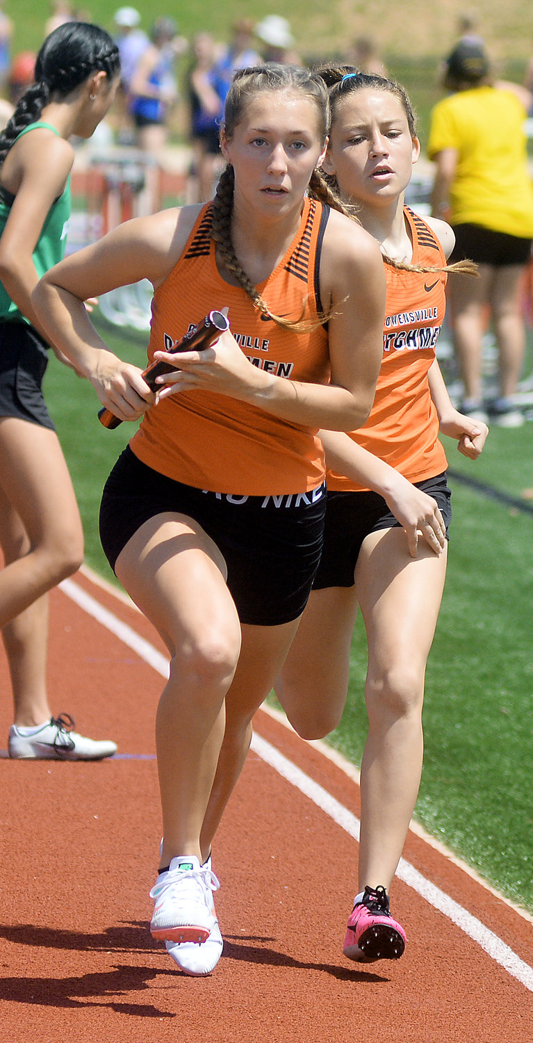 Kyah Weirich (left) secures the baton from Ilene Limberg during the girls 4x800-meter relay.